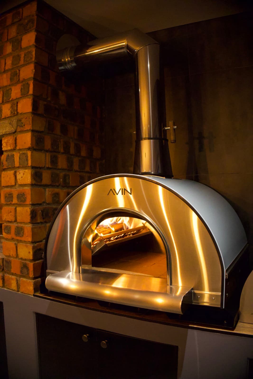 An AVIN set into a brick alcove, fire lit
